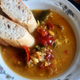 A bowl of chiff choff sauce with two slices of crusty bread sitting on the rim